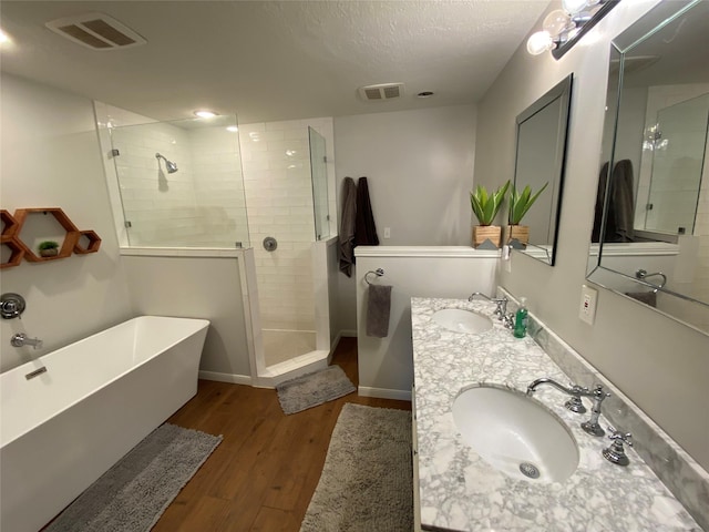 bathroom with wood finished floors, visible vents, and a sink