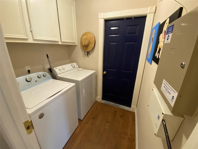 laundry area featuring washing machine and dryer, cabinet space, and wood finished floors