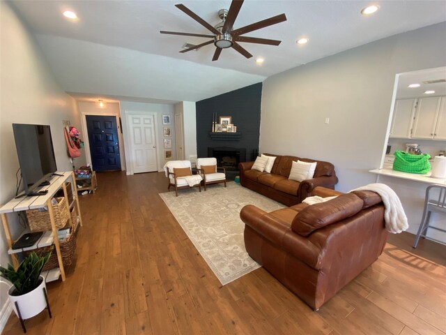living room with recessed lighting, lofted ceiling, wood finished floors, a ceiling fan, and a fireplace