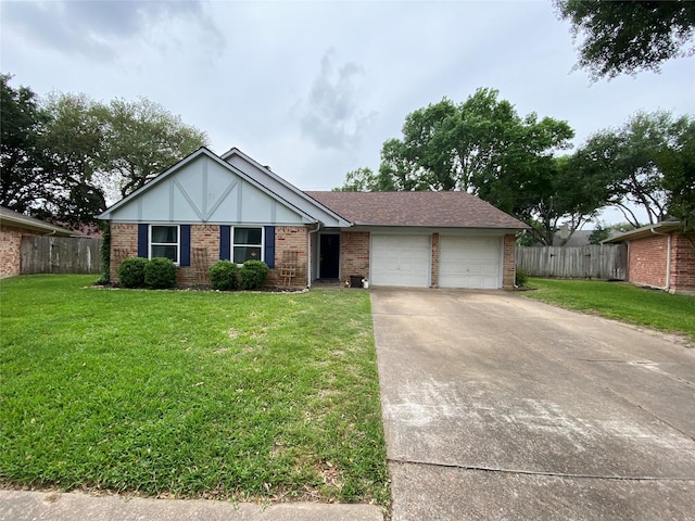 view of front of property featuring driveway, fence, a garage, brick siding, and a front yard