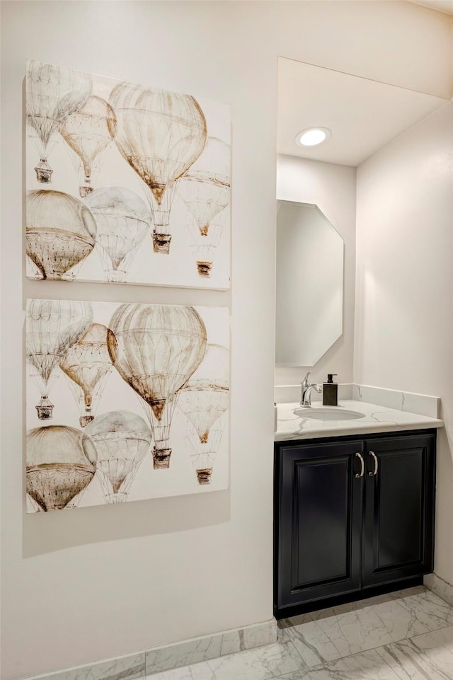 bathroom with vanity, marble finish floor, and baseboards