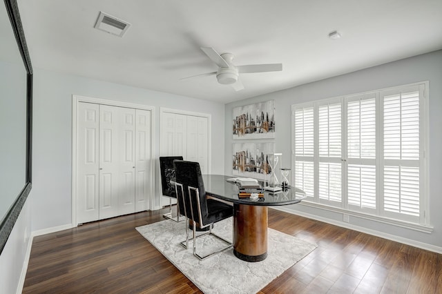 home office with visible vents, ceiling fan, dark wood finished floors, and baseboards