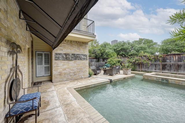 view of swimming pool featuring a pool with connected hot tub, an outdoor hangout area, a fenced backyard, and a patio area
