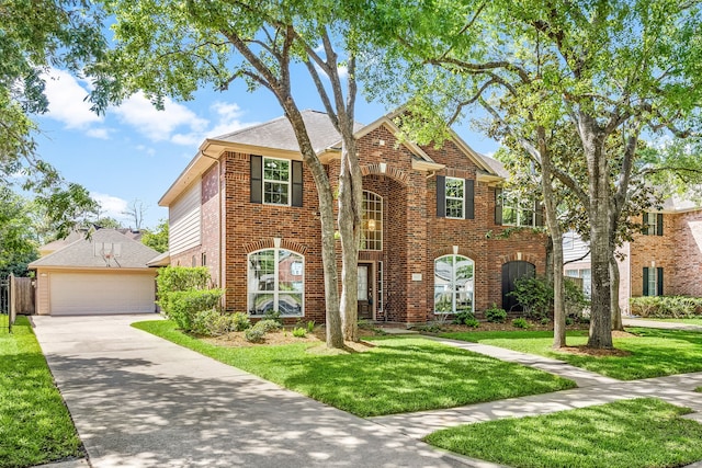 view of front of property with concrete driveway, brick siding, a front yard, and a garage
