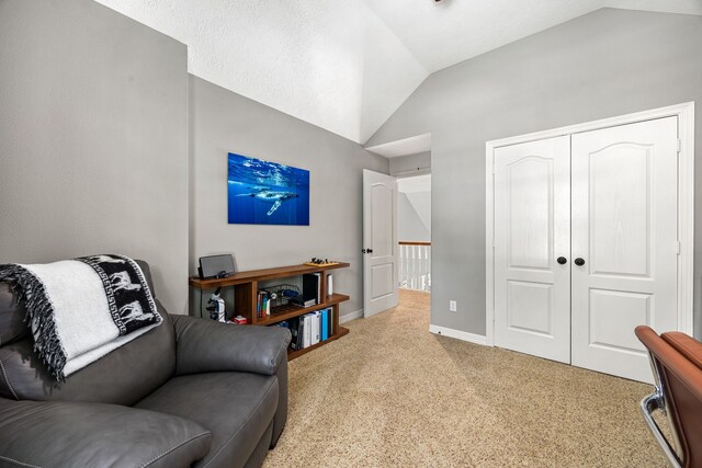 sitting room with vaulted ceiling, baseboards, and light colored carpet