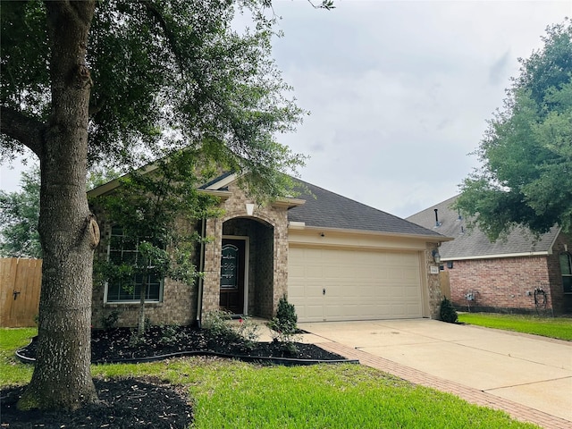 view of front of property with an attached garage, driveway, fence, and roof with shingles