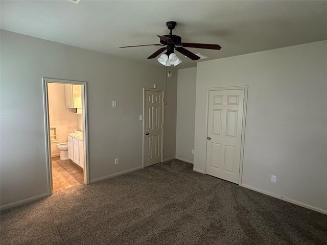unfurnished bedroom with ensuite bathroom, baseboards, and carpet floors