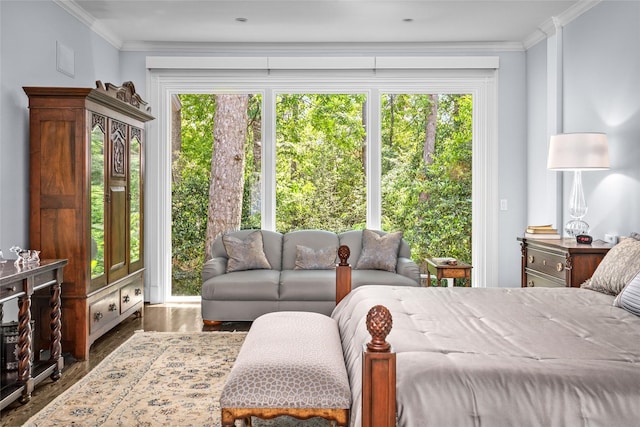bedroom with wood finished floors, ornamental molding, and access to exterior