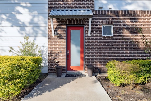 entrance to property featuring brick siding