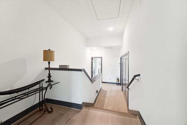 staircase featuring baseboards and wood finished floors