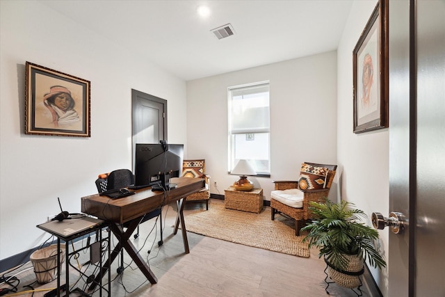 office with wood finished floors and visible vents