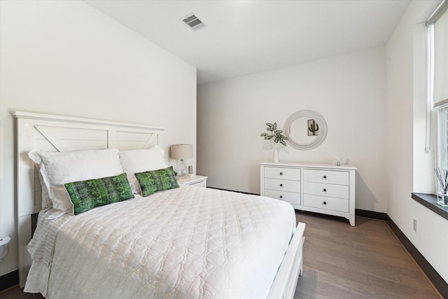 bedroom with baseboards, dark wood finished floors, and visible vents