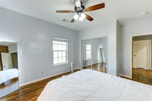 bedroom featuring wood finished floors, baseboards, and a closet