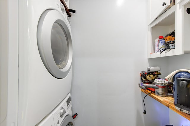 washroom with estacked washer and dryer and cabinet space