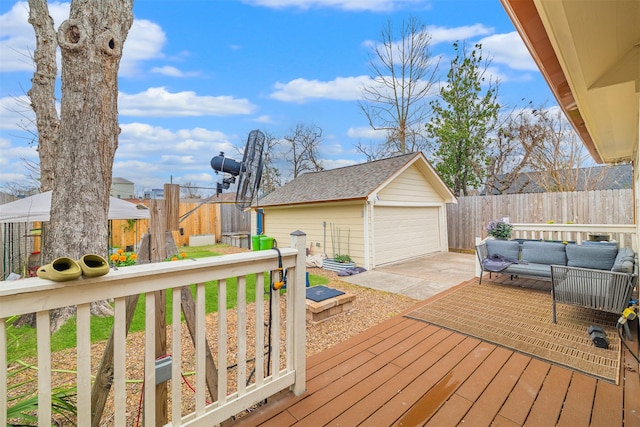wooden terrace featuring an outdoor structure, outdoor lounge area, a fenced backyard, and a detached garage