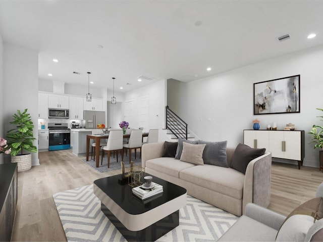 living area featuring light wood-style floors, recessed lighting, visible vents, and stairway