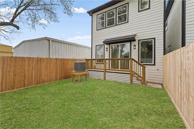 back of property with a yard, a deck, a fenced backyard, and cooling unit