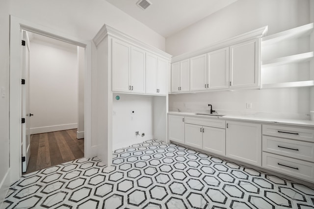 4458 Lily Bean, Montgomery, TX 77316 - laundry room with baseboards, visible vents, hookup for a washing machine, cabinet space, and a sink