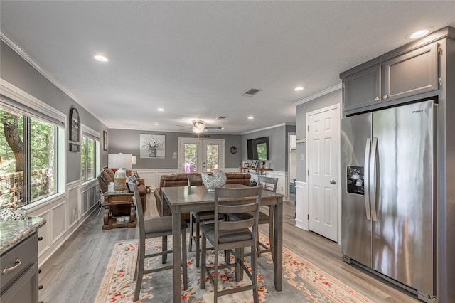 dining space with french doors, ornamental molding, light wood-type flooring, and recessed lighting