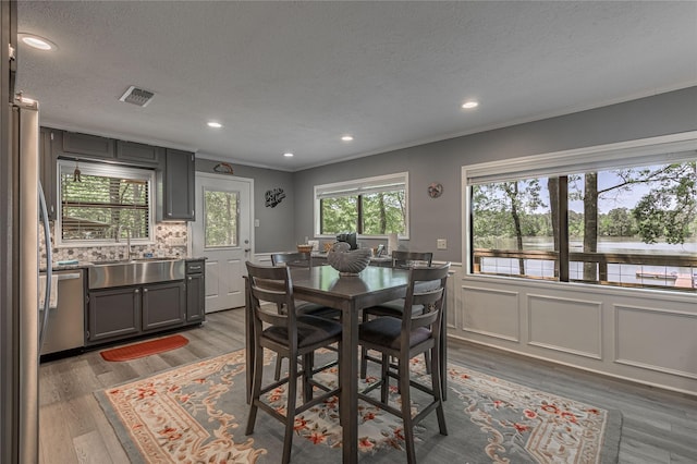 dining area with crown molding, visible vents, and a textured ceiling