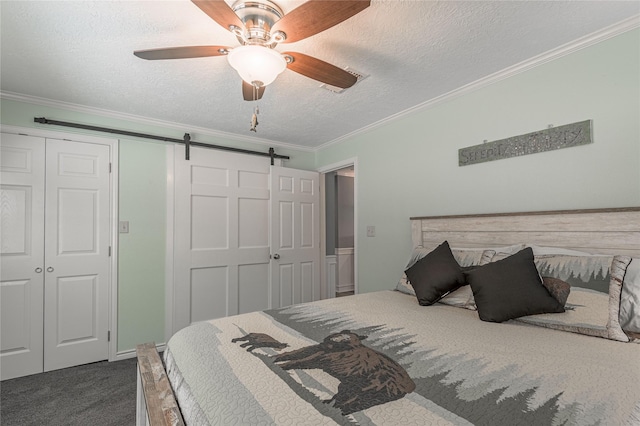bedroom featuring a closet, ornamental molding, a textured ceiling, a barn door, and dark carpet