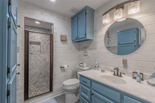 full bath featuring vanity, a stall shower, wooden walls, toilet, and visible vents