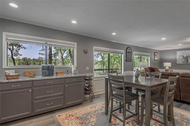 dining room featuring recessed lighting, light wood-style floors, and a textured ceiling