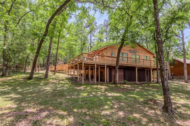 rear view of house with a yard and a wooden deck