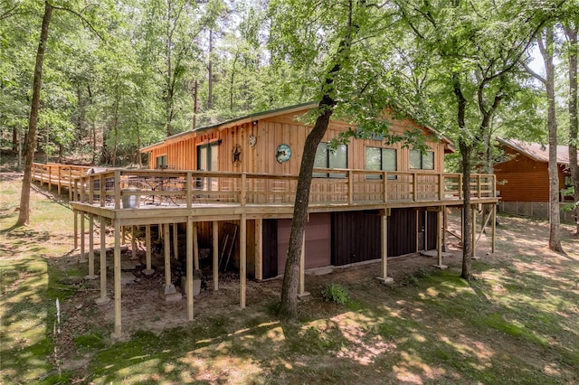 rear view of property with a view of trees and a wooden deck