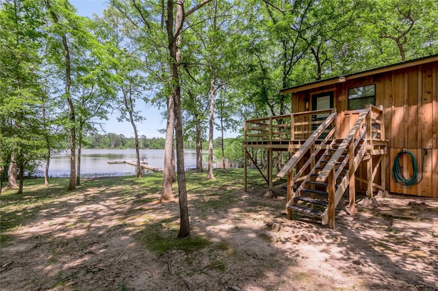 view of playground with a deck with water view and stairs