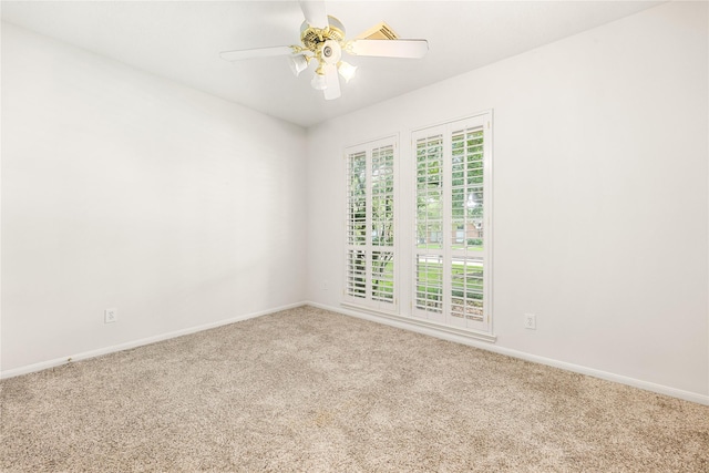 unfurnished room with baseboards, ceiling fan, and carpet