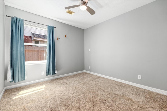 carpeted spare room with ceiling fan, baseboards, and visible vents