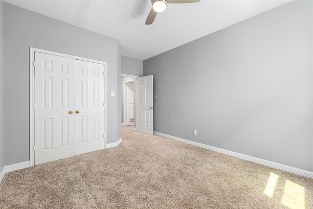 unfurnished bedroom featuring a ceiling fan, carpet floors, a closet, and baseboards