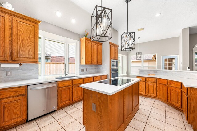 kitchen featuring light tile patterned floors, a sink, a kitchen island, tasteful backsplash, and appliances with stainless steel finishes