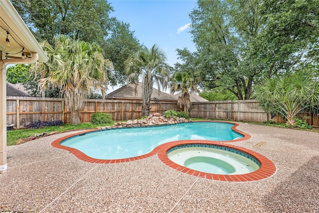 view of pool featuring an in ground hot tub, a fenced in pool, a fenced backyard, and a patio