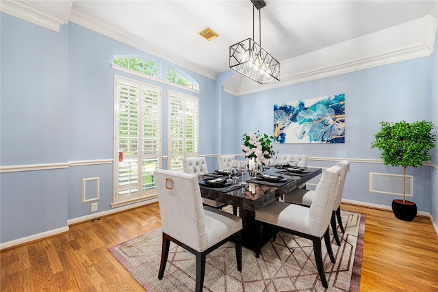 dining room featuring plenty of natural light, a chandelier, wood finished floors, and visible vents