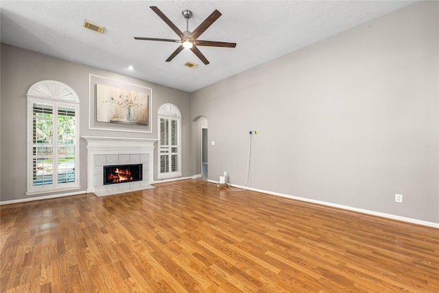 unfurnished living room featuring ceiling fan, a fireplace, light wood-style flooring, and visible vents