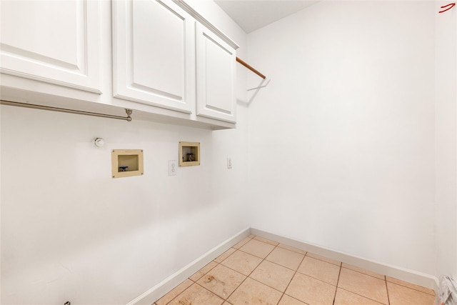 clothes washing area with baseboards, gas dryer hookup, hookup for a washing machine, light tile patterned floors, and cabinet space