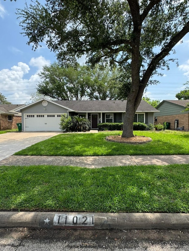 ranch-style home featuring an attached garage, a front yard, and concrete driveway
