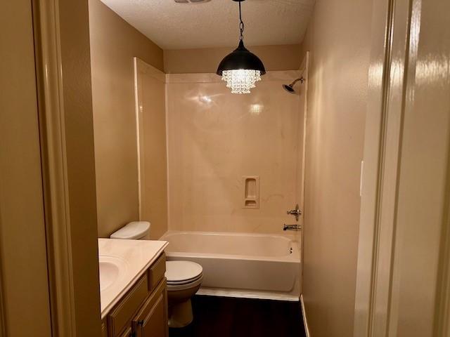 2407 Florence Dr, League City, TX 77573 - full bathroom with shower / bathtub combination, a textured ceiling, vanity, toilet, and wood finished floors