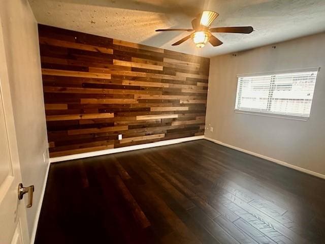 2407 Florence Dr, League City, TX 77573 - unfurnished room with wood walls, baseboards, a ceiling fan, and dark wood finished floors