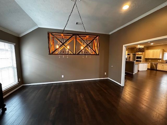 2407 Florence Dr, League City, TX 77573 - unfurnished dining area with dark wood-type flooring, a textured ceiling, ornamental molding, vaulted ceiling, and baseboards