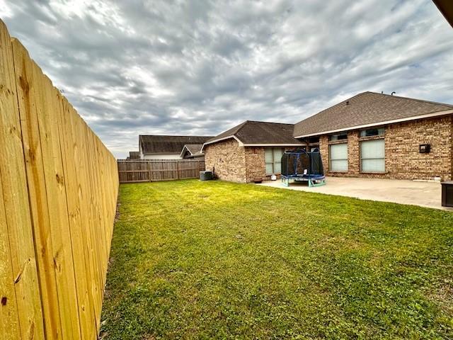 2407 Florence Dr, League City, TX 77573 - view of yard with a trampoline, a patio area, a fenced backyard, and cooling unit