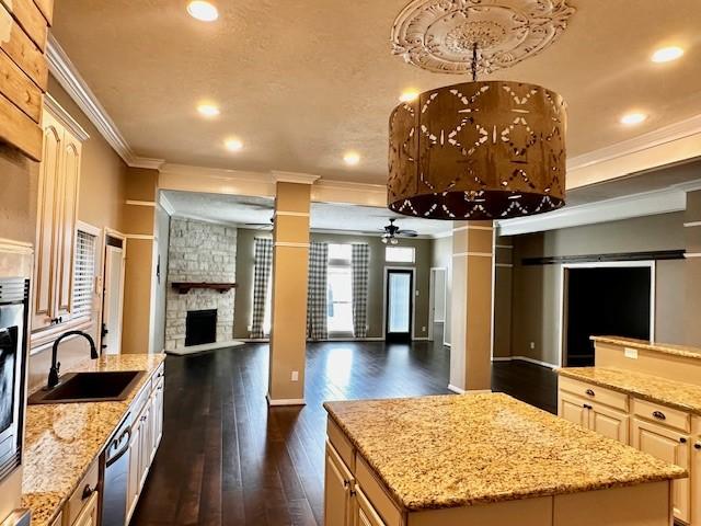 2407 Florence Dr, League City, TX 77573 - kitchen featuring decorative columns, a center island, a sink, open floor plan, and dark wood-style floors