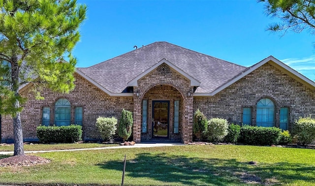 2407 Florence Dr, League City, TX 77573 - view of front facade with brick siding, roof with shingles, and a front lawn