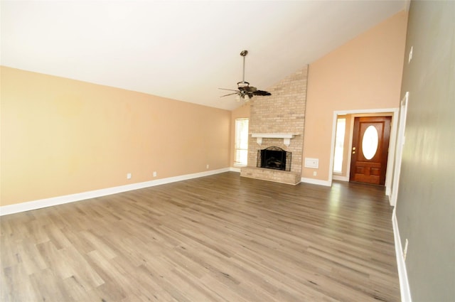 unfurnished living room featuring a fireplace, ceiling fan, high vaulted ceiling, baseboards, and wood finished floors