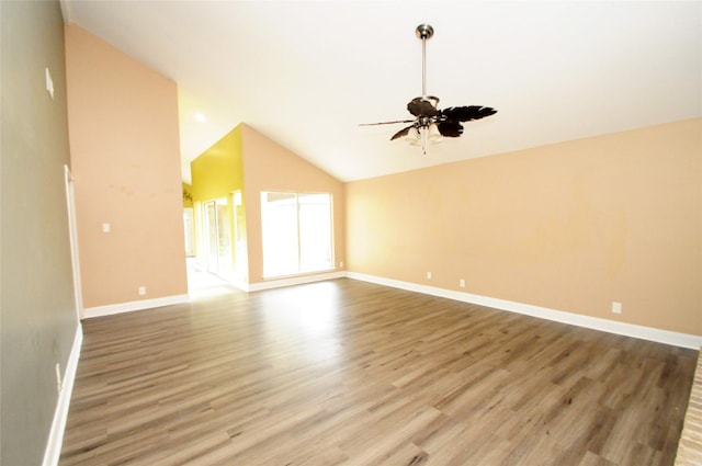 unfurnished living room with lofted ceiling, ceiling fan, wood finished floors, and baseboards