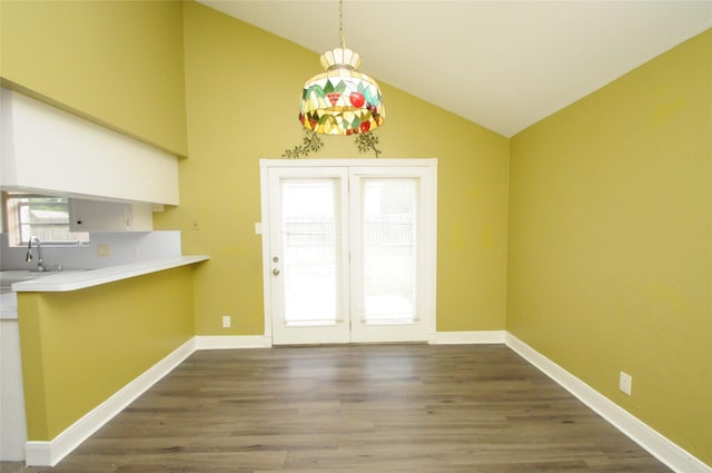 unfurnished dining area featuring wood finished floors, lofted ceiling, and a sink