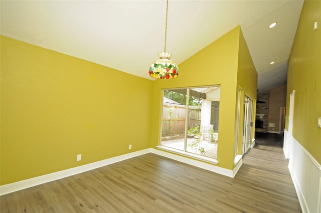 unfurnished dining area featuring baseboards, recessed lighting, wood finished floors, and high vaulted ceiling