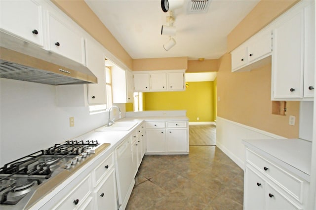 kitchen with white cabinetry, a sink, white dishwasher, under cabinet range hood, and stainless steel gas cooktop
